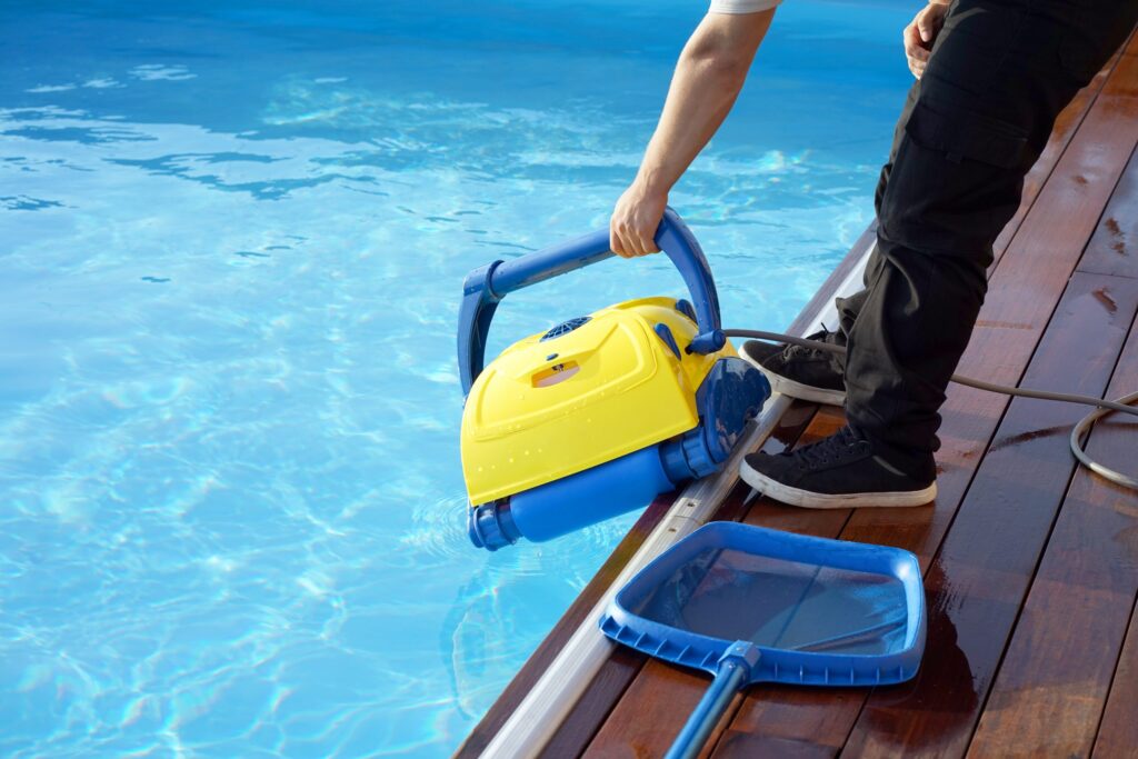 hotel staff worker cleaning the pool. automatic pool cleaners.