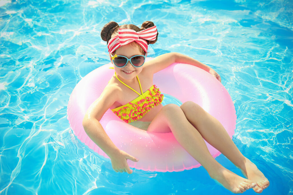 Keep Pool Season Going When the Kids Head Back to School little girl in swimming pool on sunny day