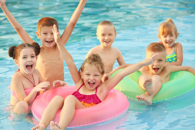 little kids in swimming pool on sunny day