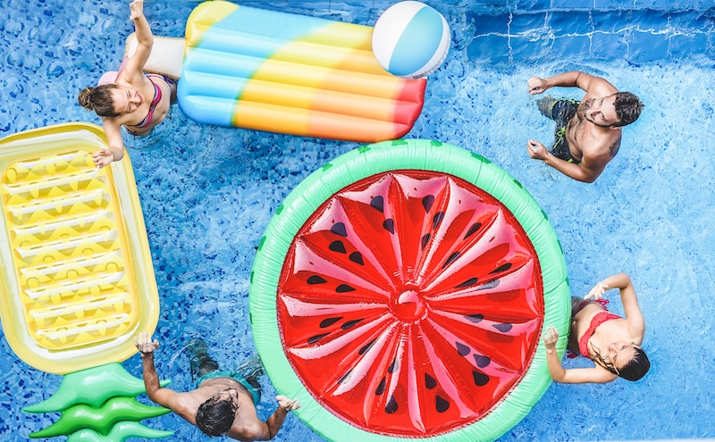 happy friends playing with ball inside swimming pool young people having fun on summer holidays vacation travel,holidays,youth,friendship and tropical concept seasonal color tones filter